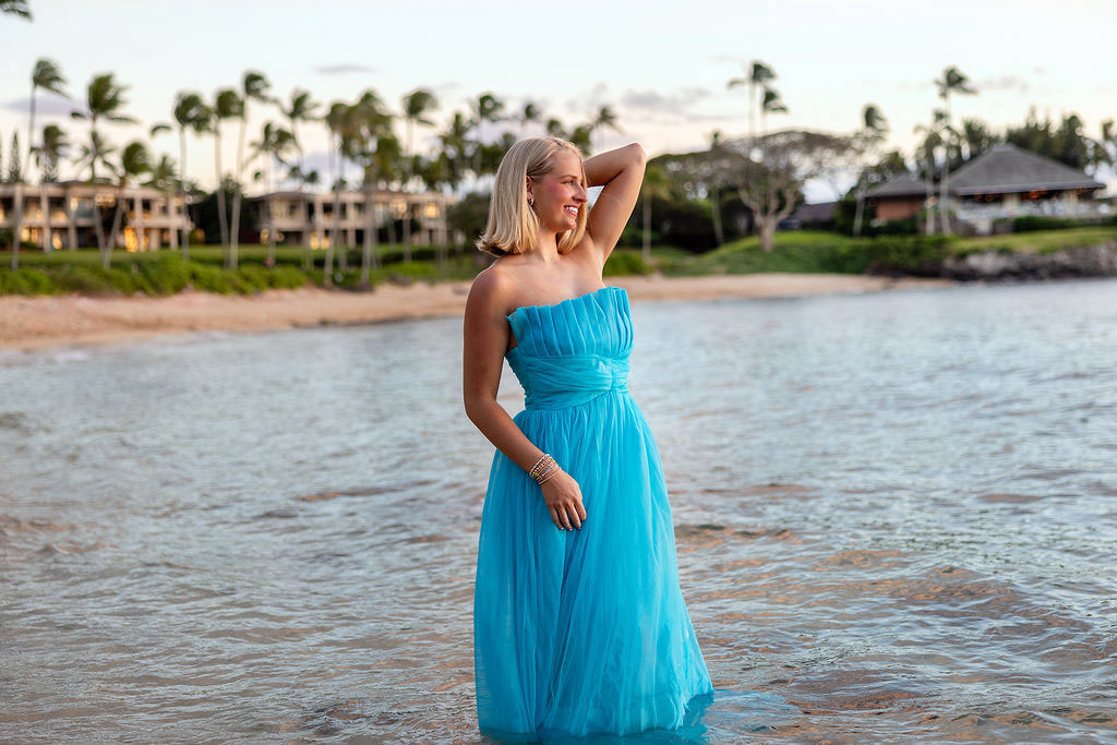 Senior girl smiling at sunset on Kapalua Beach with ocean in the background
