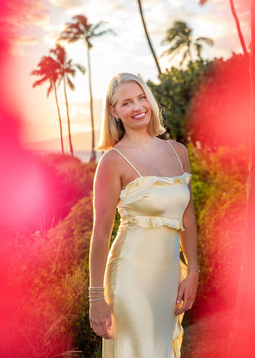 Close-up of a senior girl laughing with palm trees in the background