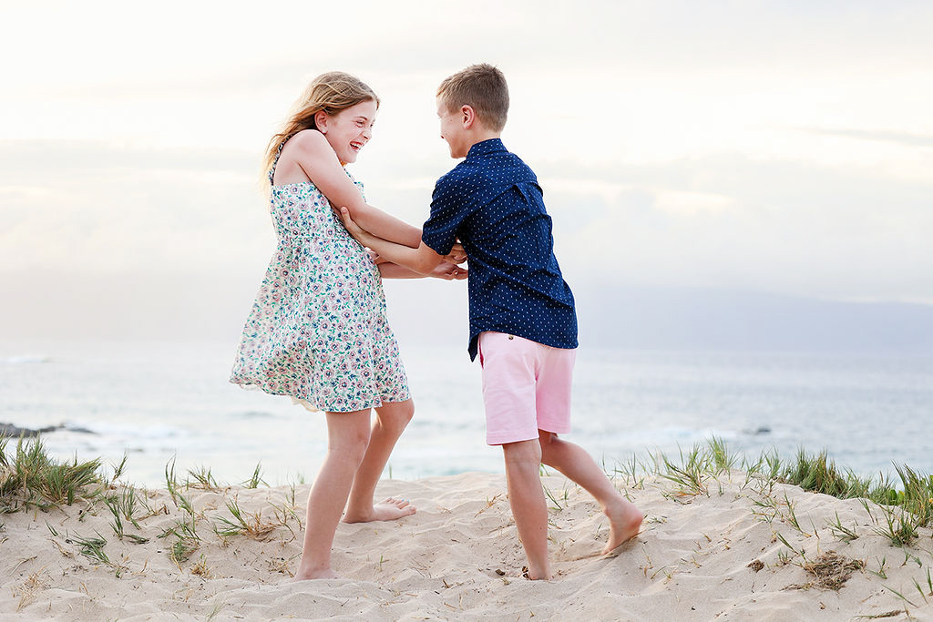 kids playing in the sand, laughing together on the shoreline