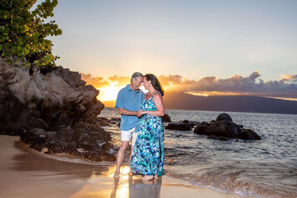 Sunset over calm waters at Kapalua Bay with soft reflections and lava rocks