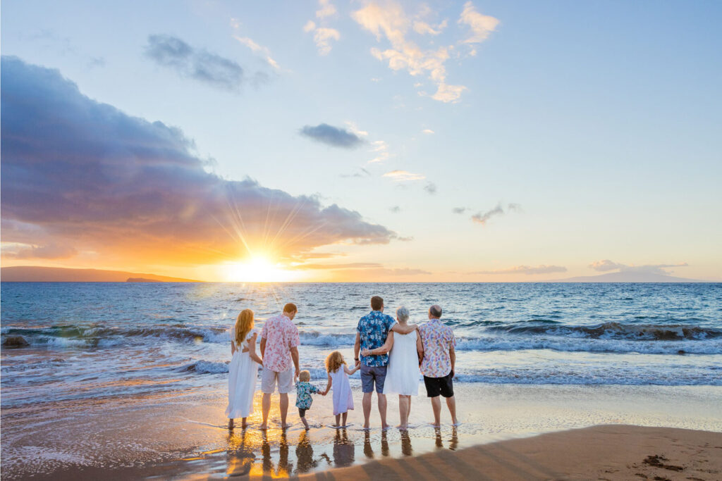 Family hugging at Po‘olenalena Beach with soft sunset light