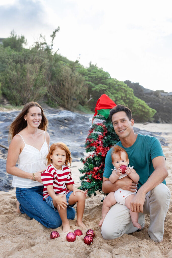 Parents with children smiling on the shoreline, creating timeless holiday cards in Maui