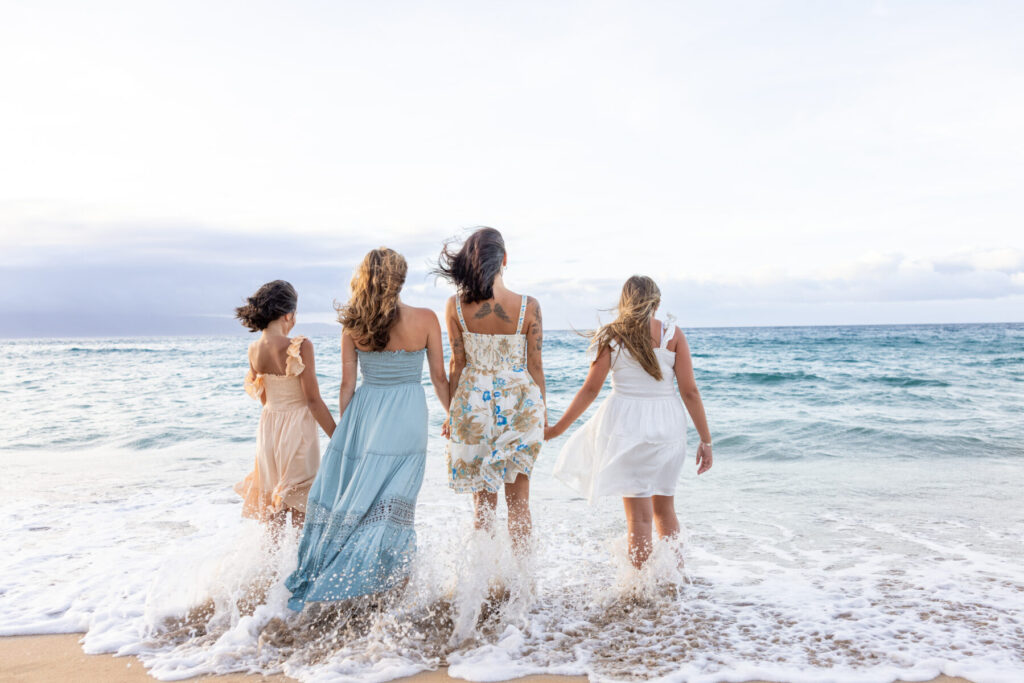 Family coordinated in soft pastel colors during Maui beach portraits