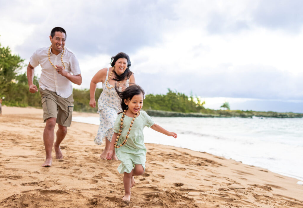 Family coordinated in soft pastel colors during Maui beach portraits