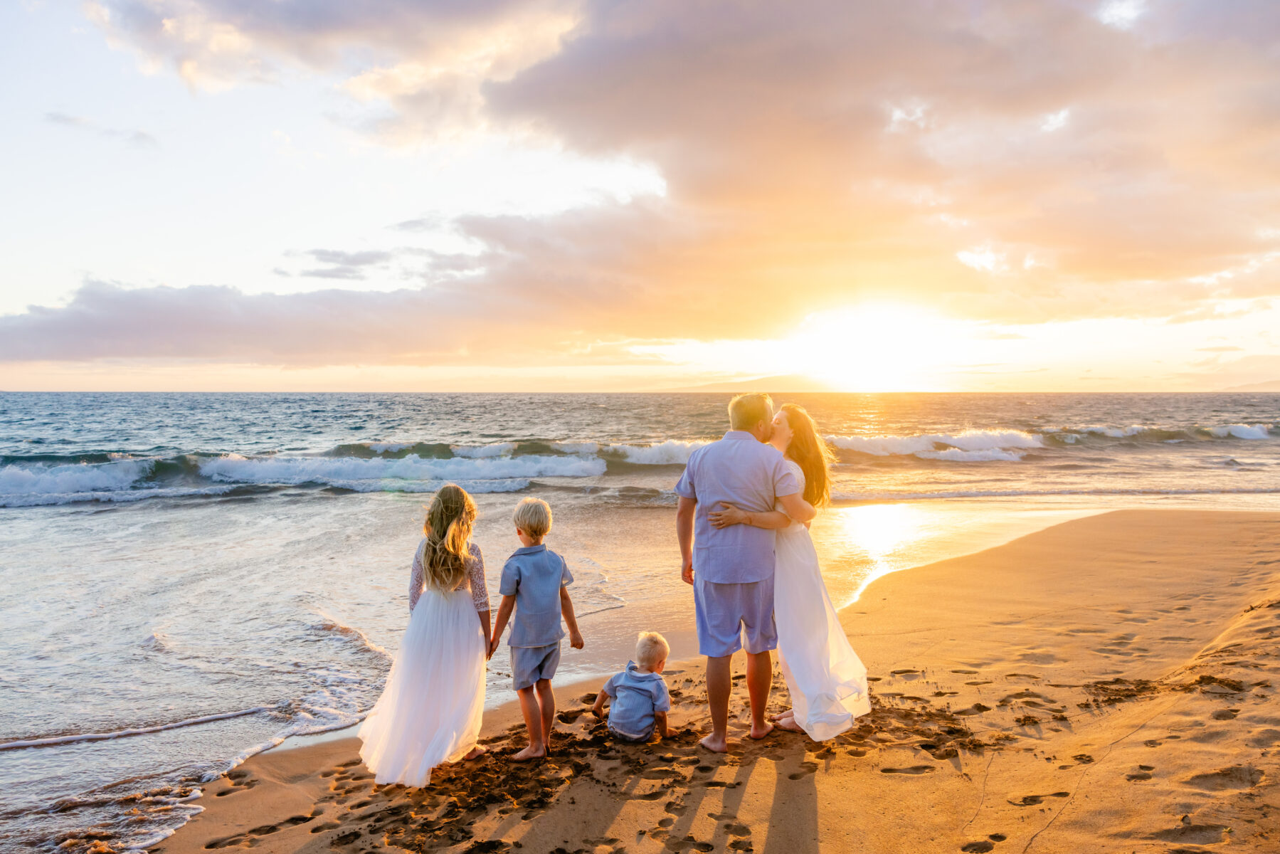 Family coordinated in soft pastel colors during Maui beach portraits