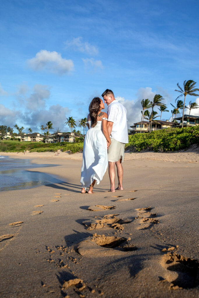 Romantic walk on the rocks during a Maui couple photo session at Ironwoods Beach, couple holding hands at sunset.