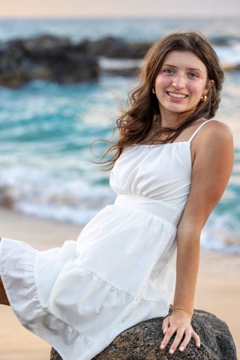 Teen girl smiling in a white dress during a Maui senior portraits session.