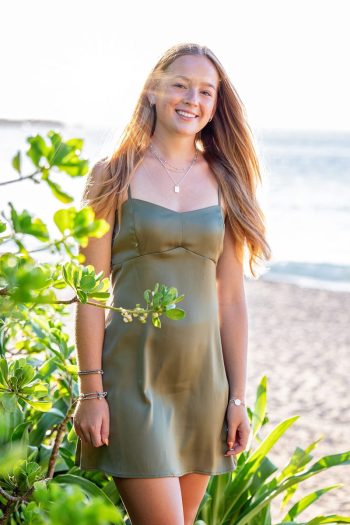High school senior girl standing near greenery during a Maui photoshoot.