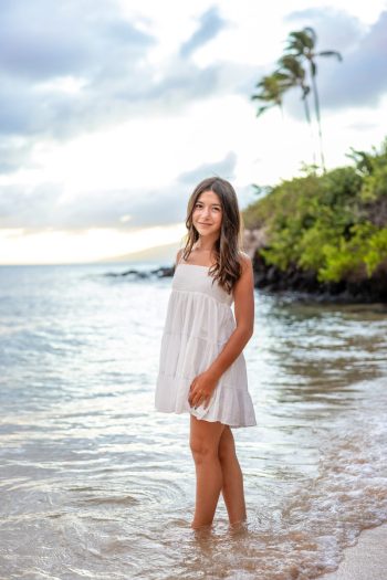 Senior girl standing in shallow water during a Maui beach portrait