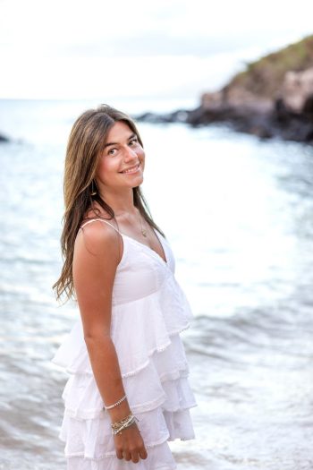 High school senior girl smiling by the ocean during a Maui session