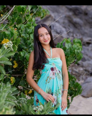 High school senior posing near greenery during a Maui portrait session.