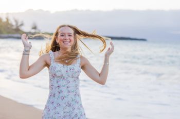 Senior girl smiling with ocean behind her in Maui.
