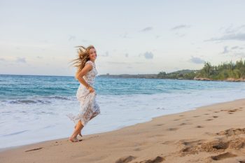 Teen girl walking along the shoreline during a Maui photoshoot