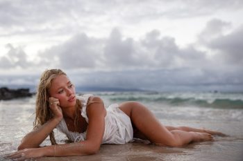 Woman lying on the beach during a Maui boudoir-style portrait session.