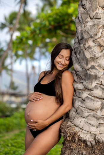 Pregnancy photo session Maui – gentle hand resting on baby bump.