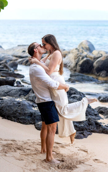 Maui proposal photography – intimate reaction captured on lava rocks.