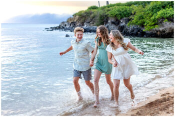 Maui family photographer – cousins running through shallow surf at Kapalua