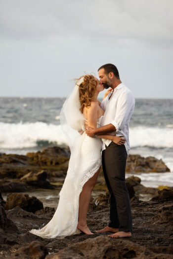 Engagement photoshoot Maui – couple kissing barefoot as waves roll in.