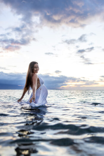 Maternity photoshoot in Maui – soft sunset light touching flowing gown