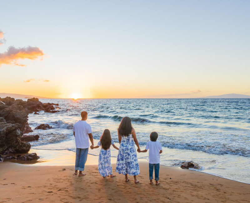 Family photoshoot in Maui – barefoot walk along the shoreline during pastel sunset.