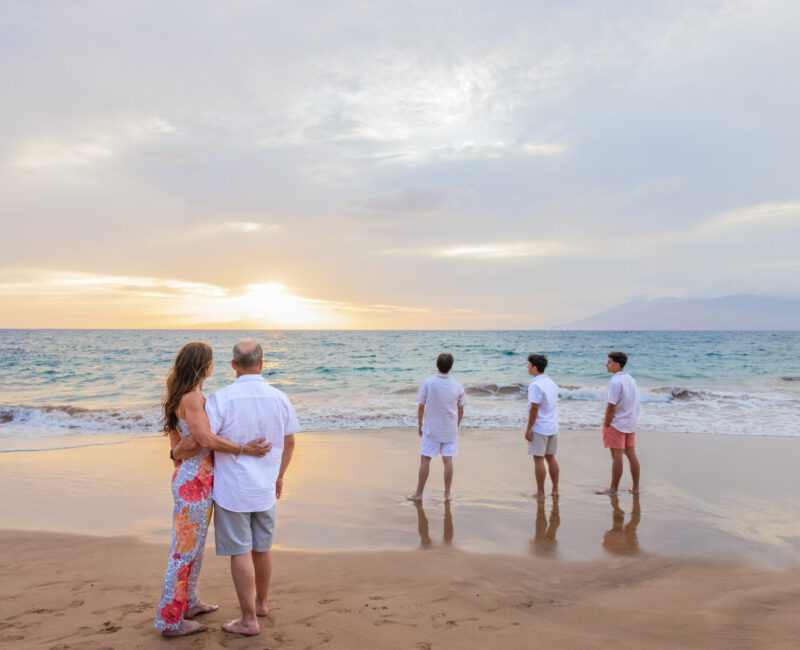 Family beach portraits – glowing sunset wrapping around a family embrace.