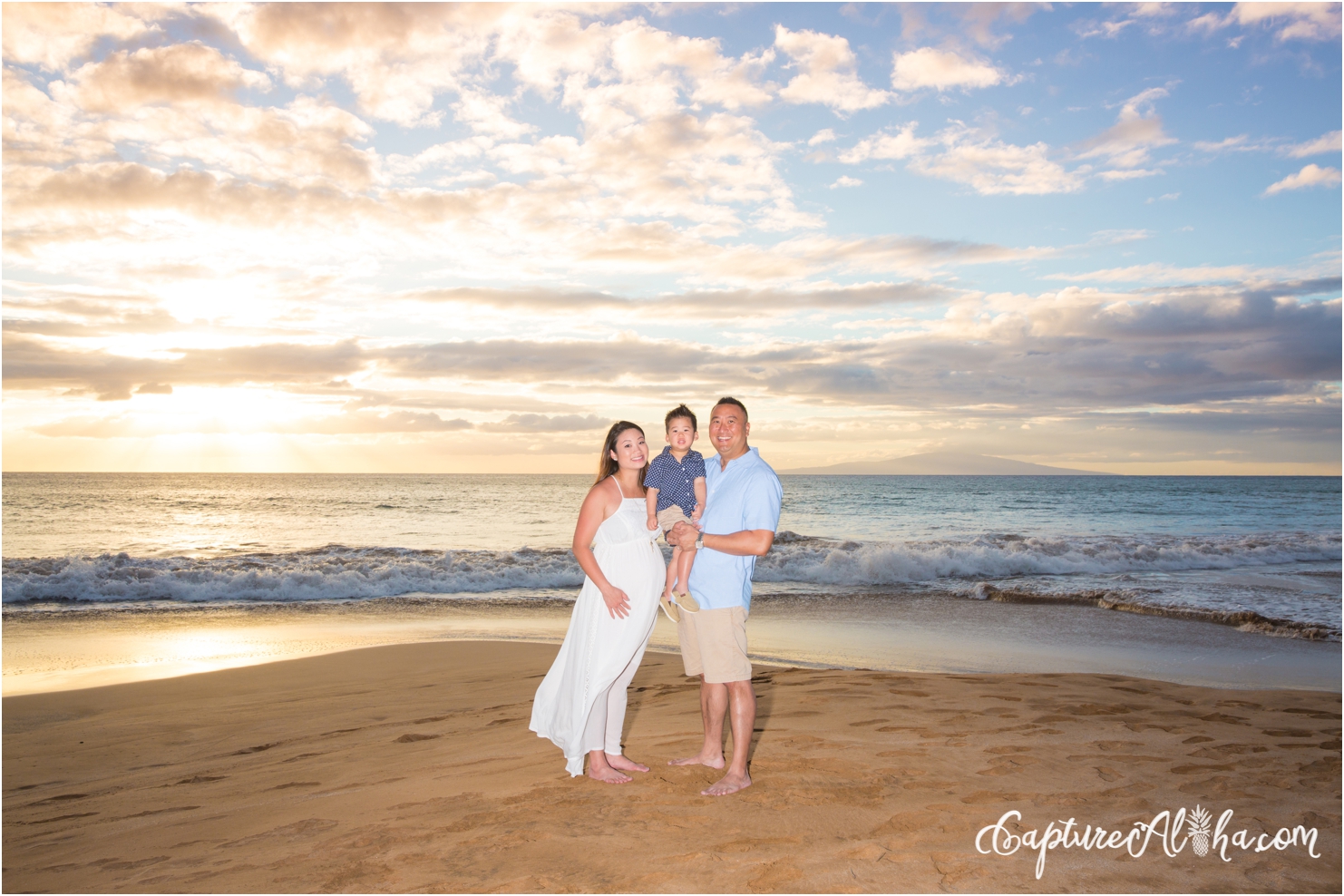 family portrait with expecting parents and toddler on a Maui Beach
