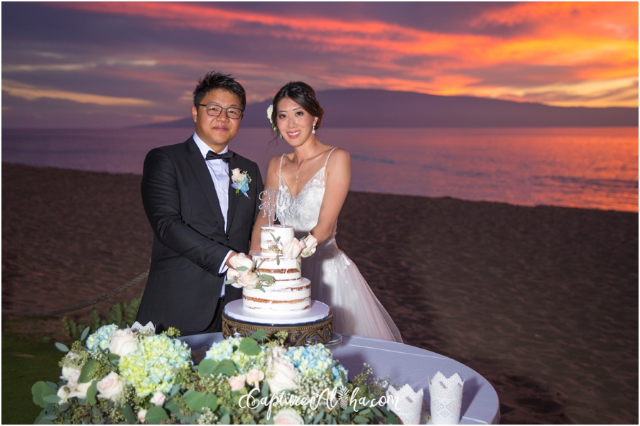 bride and groom with the wedding cake at sunset