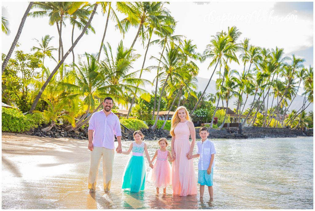 Family photography on Baby Beach in Lahaina, Maui in the morning with family holding hands walking