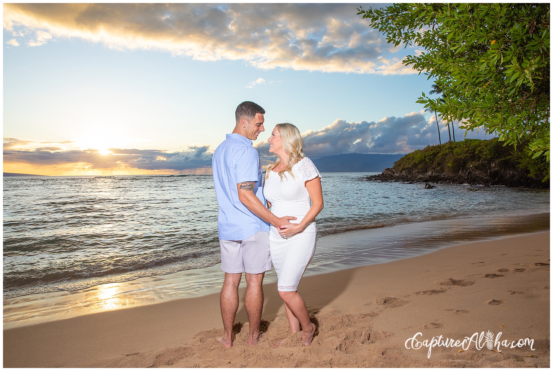 Wife and husband on a maternity photoshoot in Maui on the beach with the sunset