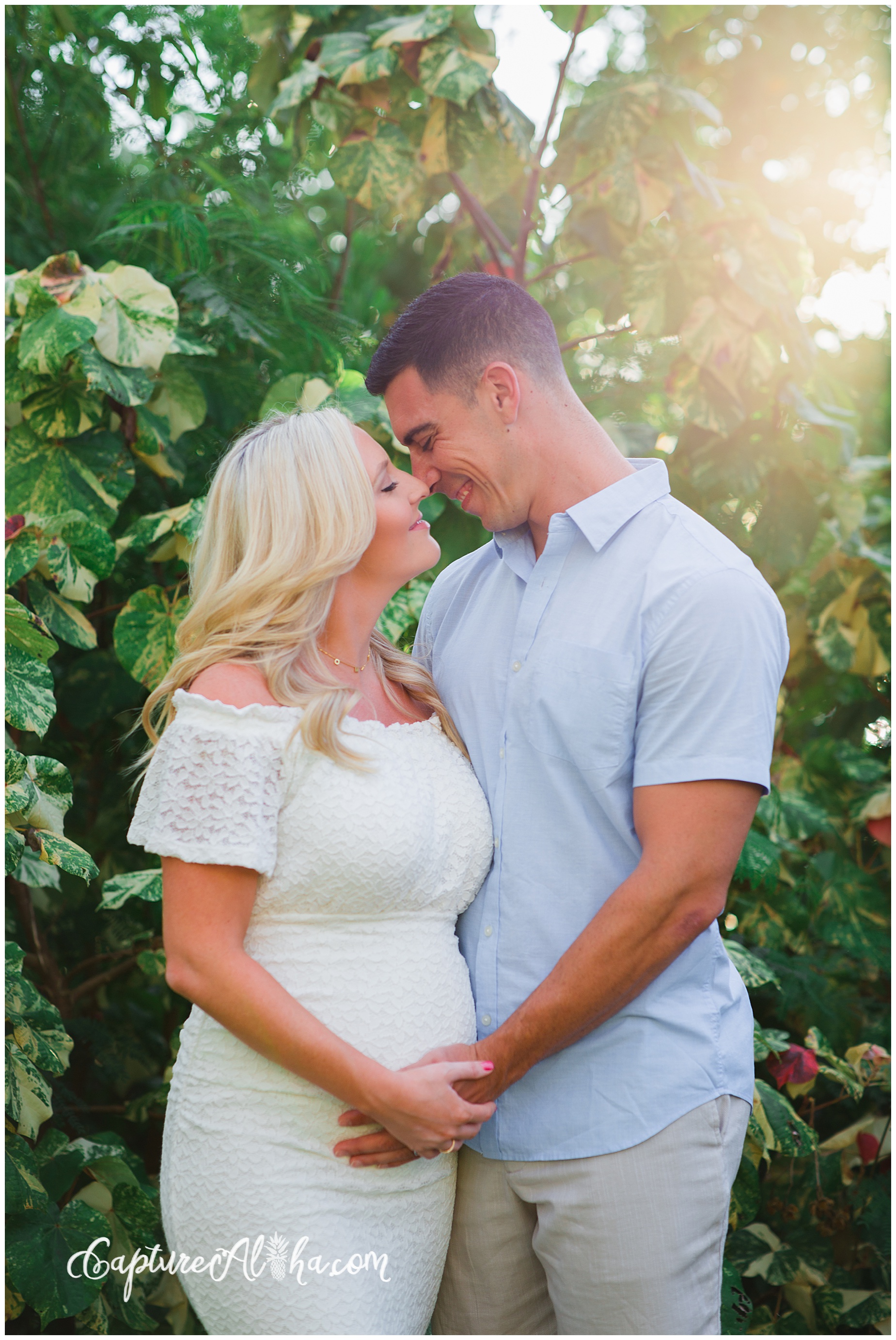 Wife and husband on a maternity photoshoot in Maui with greenery in the backgroun