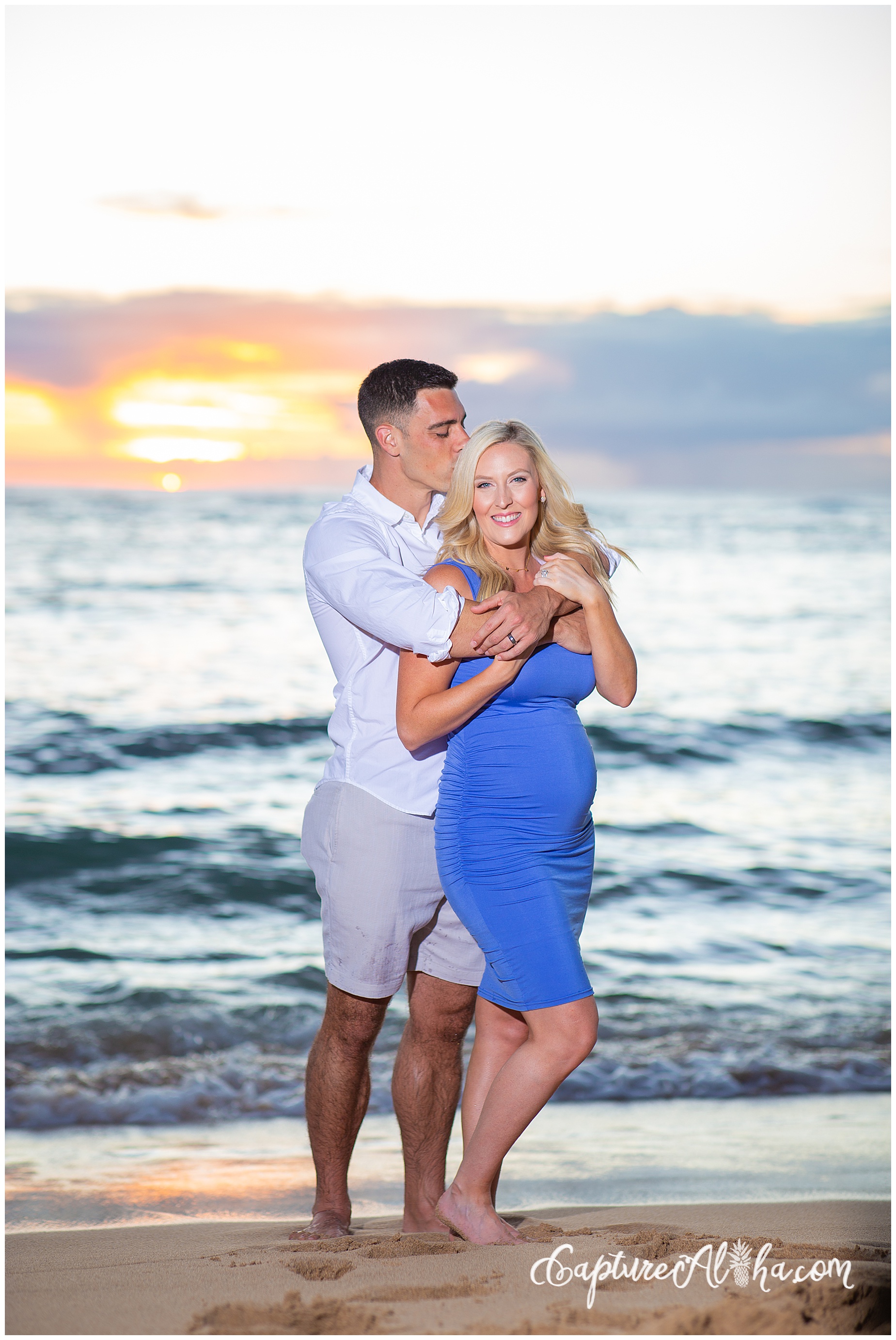 Wife and husband on a maternity photoshoot in Maui on the beach with the sunset