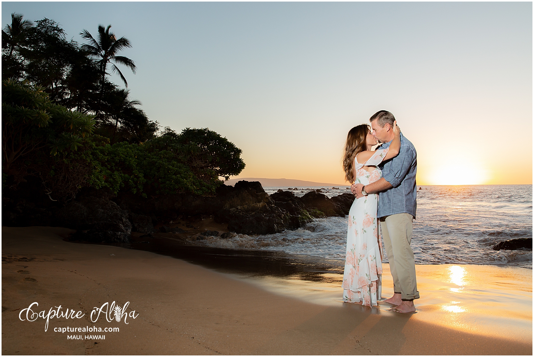 Maui Couples Photography at Mokapu Beach, Maui at sunset with couple kissing and palm trees in the background